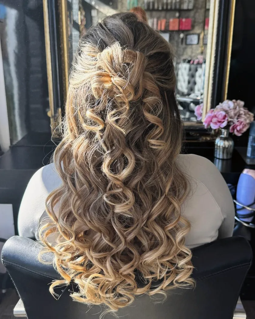 Very long hair, brown at the root blending to blonde, half pinned back and curled into ringlets, seen from behind