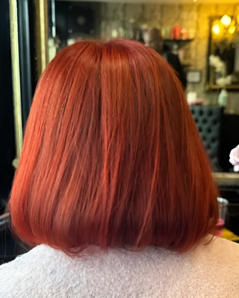 Smooth shoulder-length bob in bright copper red, seen from behind