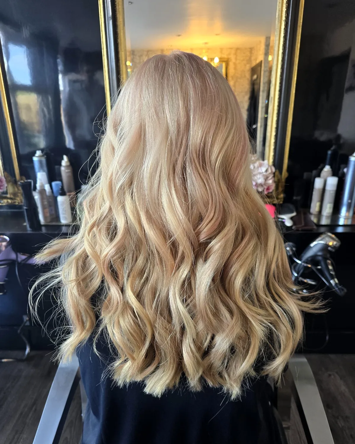 Long golden-blonde hair in loose waves, seen from behind